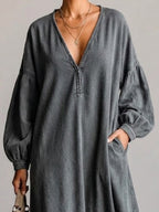 Washed, Distressed, Loose-fit Denim Dress Featuring A V-neck, Long Lantern Sleeves, And A Fringed Hem